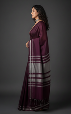 Woman wearing a purple saree with a gray pallu