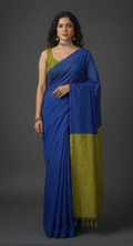 Woman wearing a blue and green saree against a gray background