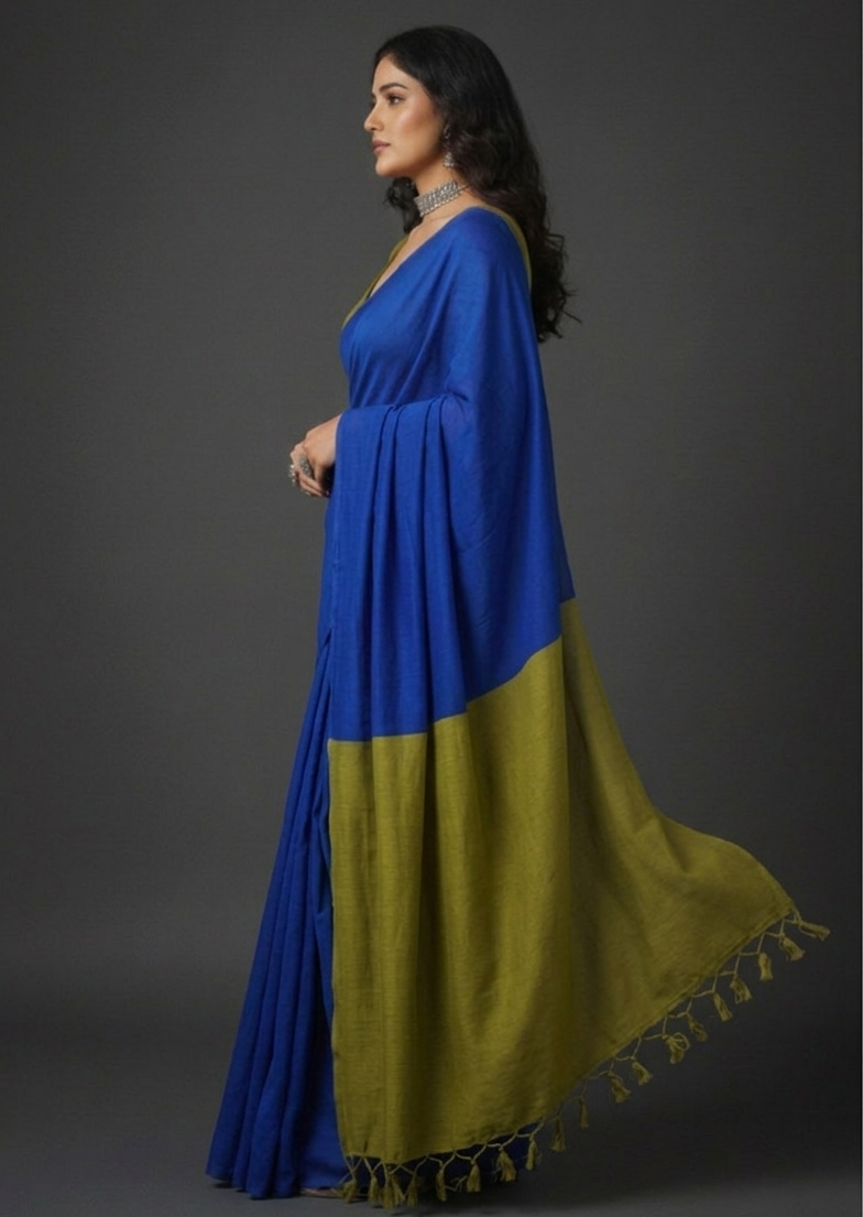 Woman wearing a blue and green saree with a plain background