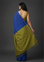 Woman wearing a blue and green saree against a gray background