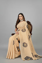 Woman in a beige saree with black floral patterns 