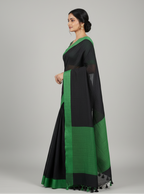 Woman wearing a black and green saree 