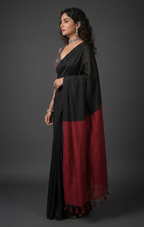 Woman wearing a black and red traditional outfit against a gray background